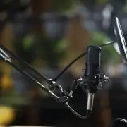 Modern black microphone and headphone in music studio