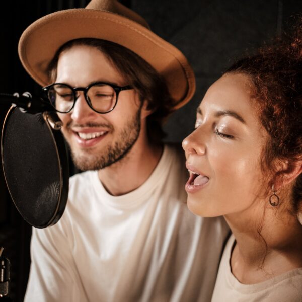 Young musicians sensually singing working together on new music album in sound recording studio