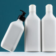 A set of cosmetic bottles on a white shelf with a place for your logo. The concept of routine body skin and hair care, toiletries.